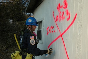 Biloxi, Miss., September 3, 2005 -- A member of the Indiana Task Force 1 Urban Search and Rescue (US&R) team marks a damaged house after searching for victims of Hurricane Katrina. The gulf coast of Mississippi sustained extreme damage from the hurricane. FEMA/Mark Wolfe